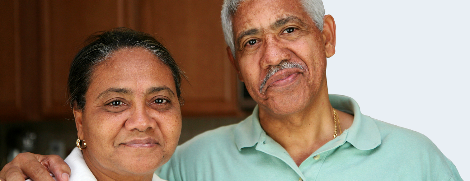 A close up portrait of an elderly Hispanic couple in their home.