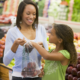 Woman and daughter grocery shopping for produce